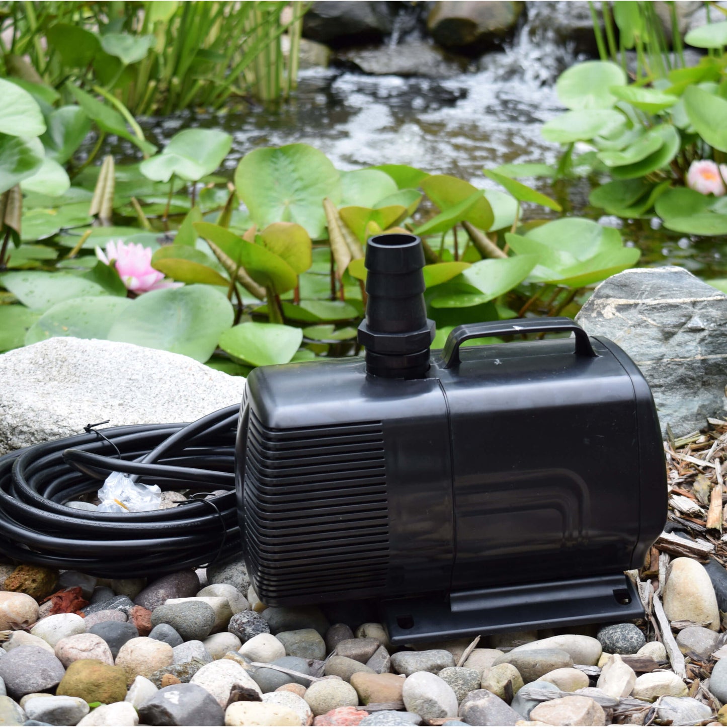 EasyPro EP850 mag drive pump beside pond with lily pads and waterfall in background