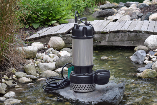 EasyPro TM9500 pump on rock with pond stream and wooden bridge in background