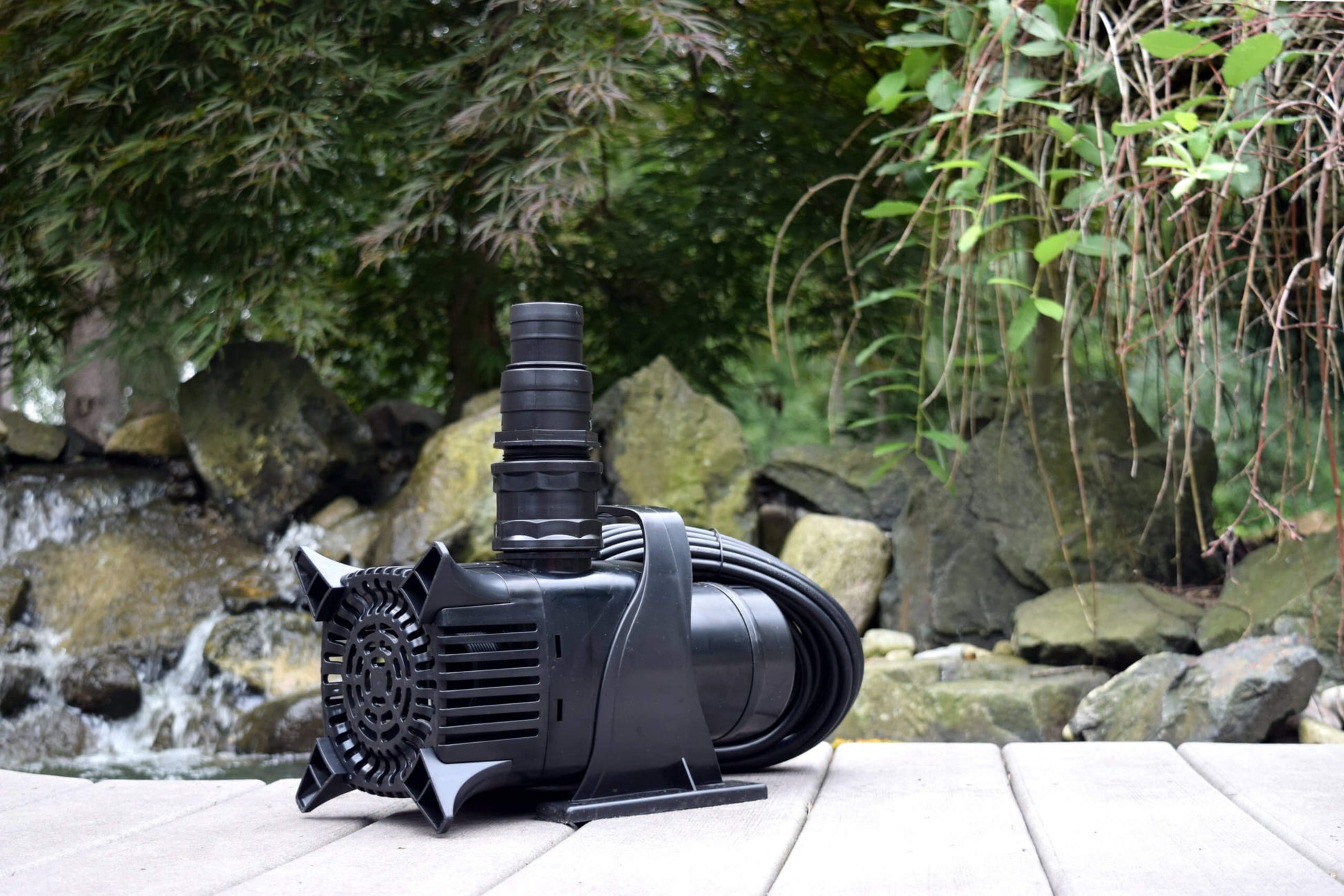 EasyPro EPA9500 mag drive pump on deck with pond waterfall and rocks in background
