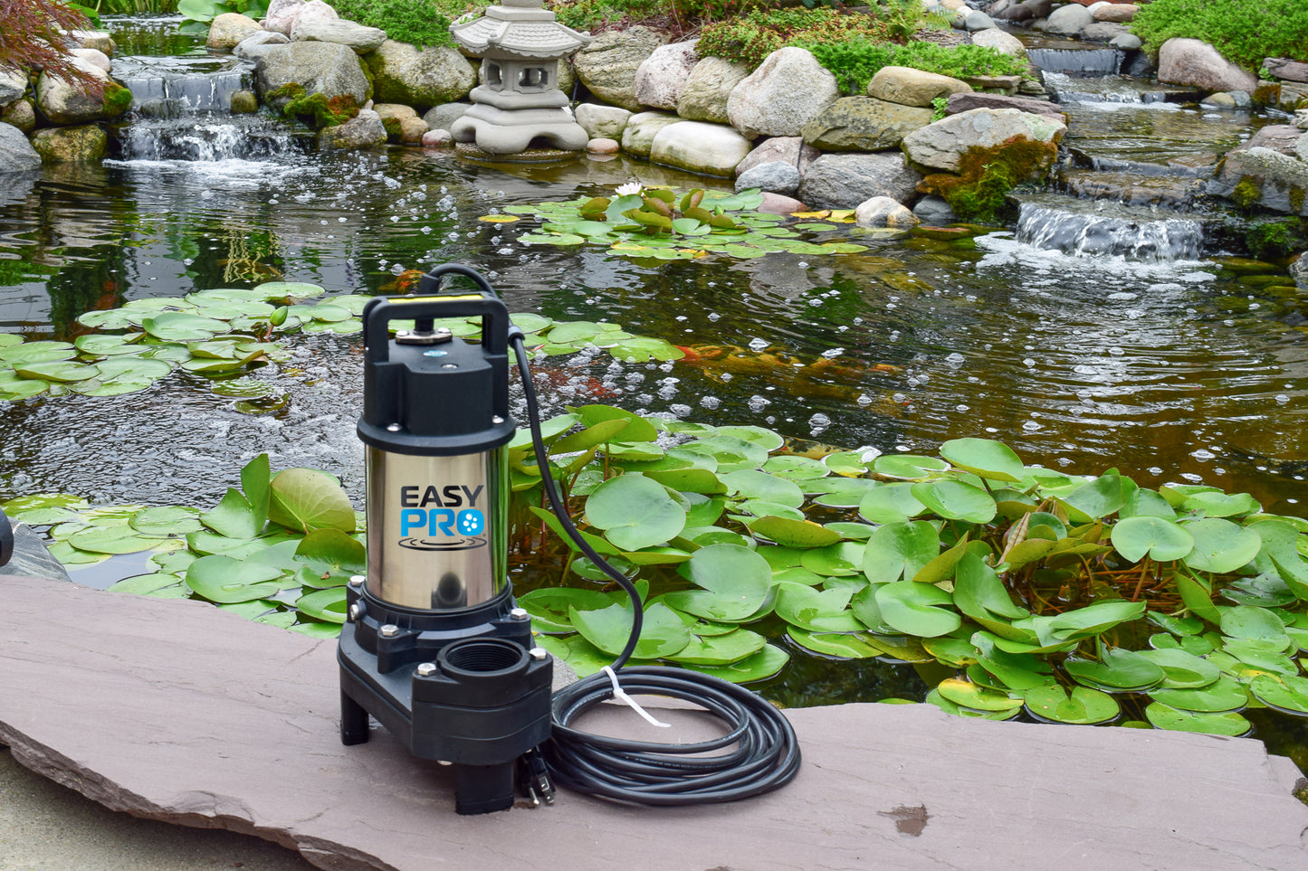 EasyPro TH150 stainless steel pump with backyard koi pond and waterfalls in background