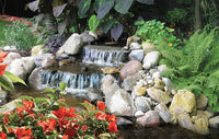 Garden waterfall and stream with rocks, ferns and colorful plants in background