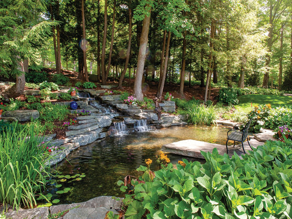 Tranquil backyard oasis featuring a picturesque pond with a flowing waterfall